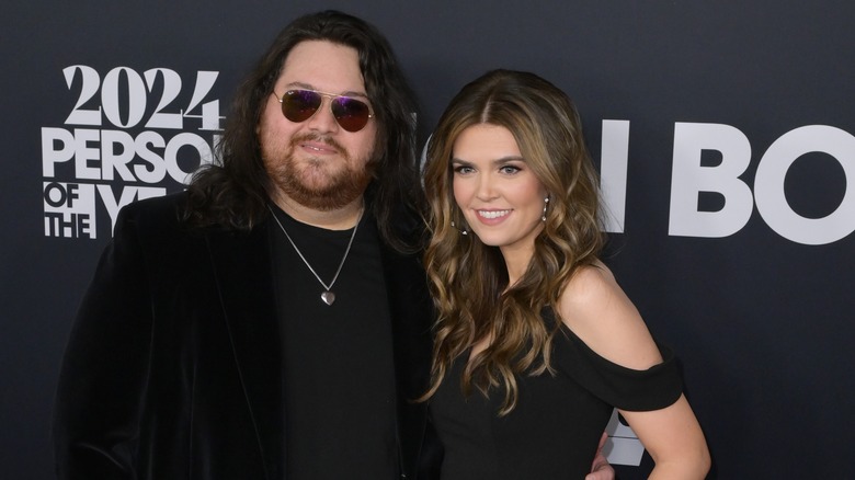 Andraia Allsop and Wolfgang Van Halen smiling on step-and-repeat