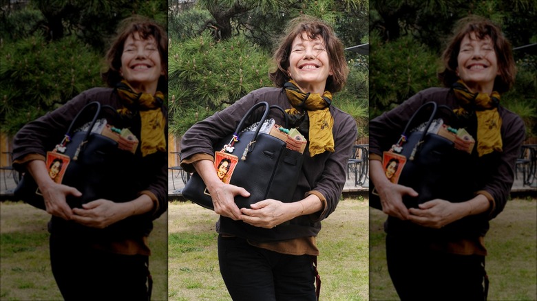 Jane Birkin carrying Birkin bag smiling