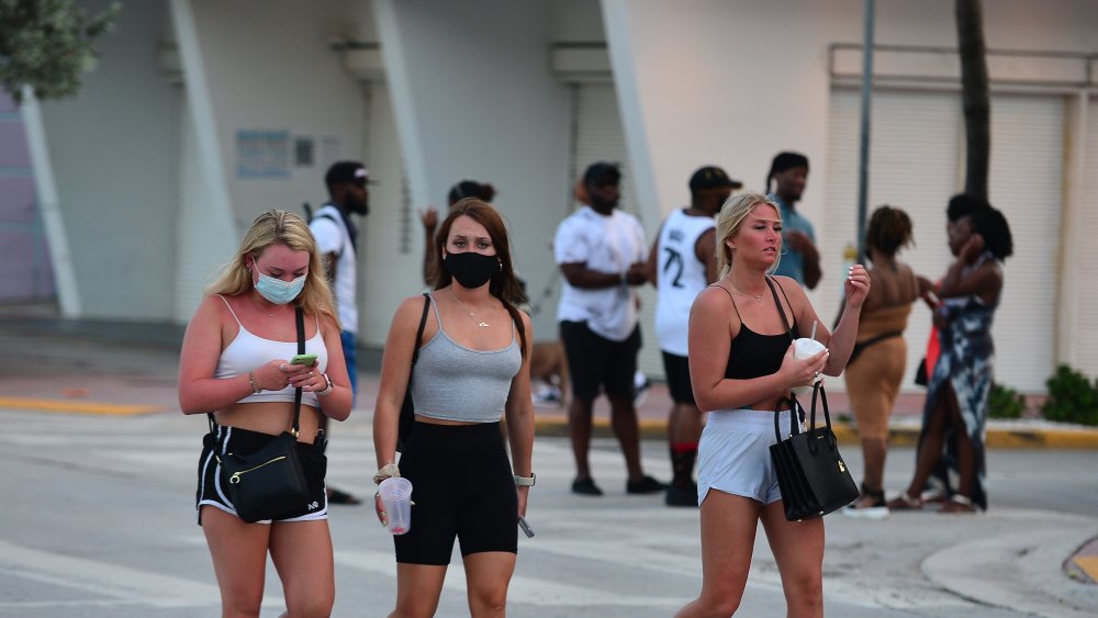 Group of women wearing masks on a public beach