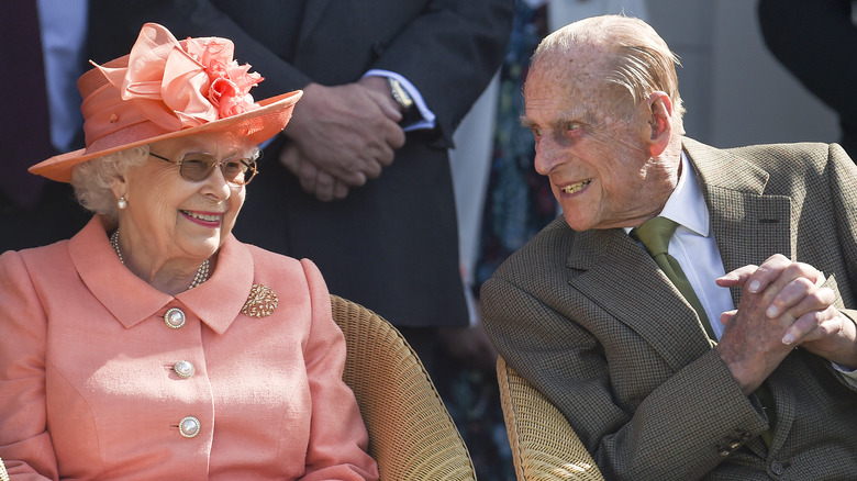 Queen Elizabeth and Prince Philip smiling at each other