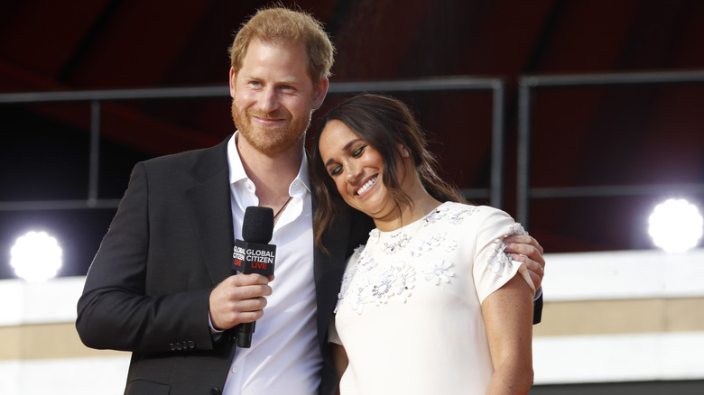 Meghan Markle and Prince Harry cuddle up onstage