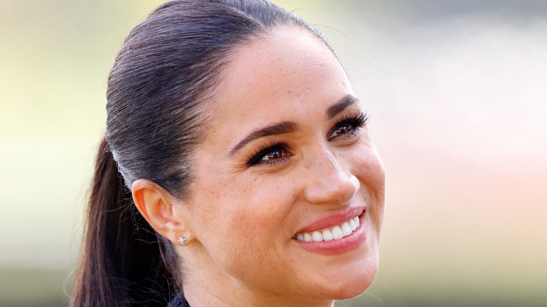 Meghan Markle smiling with a ponytail