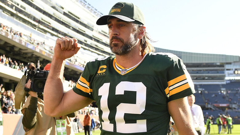 Aaron Rodgers walking off the field on his Packers hat and jersey