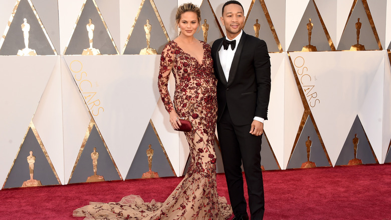 Chrissy Teigen and John Legend posing for photos