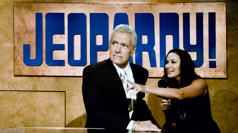 Alex Trebek under Jeopardy sign