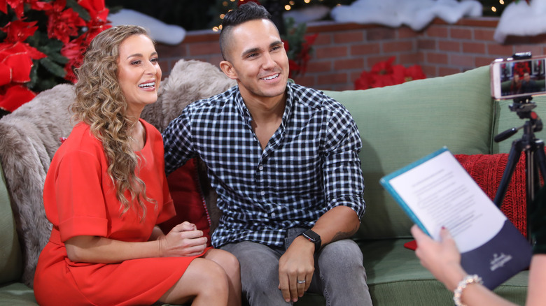 Alexa and Carlos PenaVega sitting on a couch together