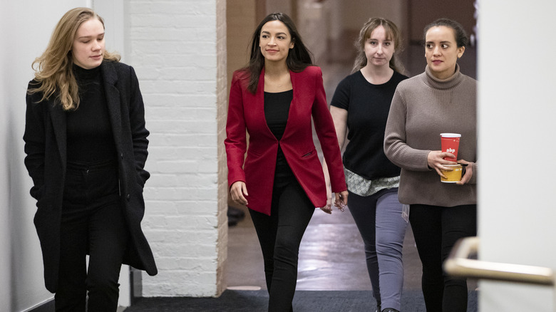 Alexandria Ocasio-Cortez and staff arrive at a press conference