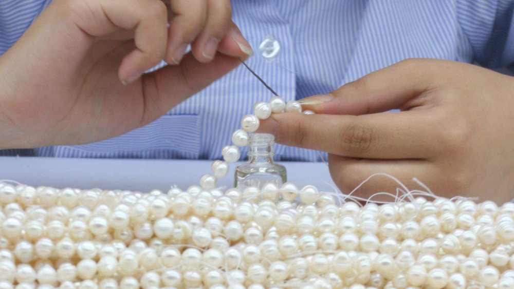 Freshwater pearls being threaded in China