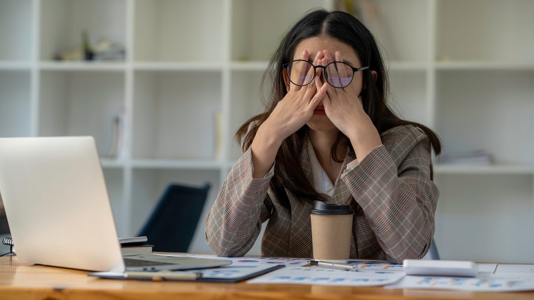 Woman with head in hands at desk