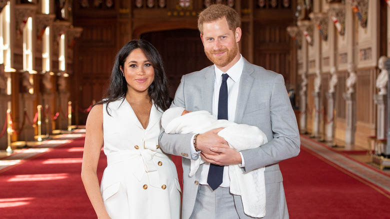 Meghan and Harry smiling at cameras with baby Archie