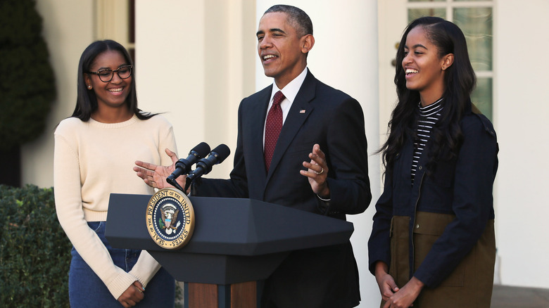 Sasha, Barack, and Malia Obama sharing a laugh