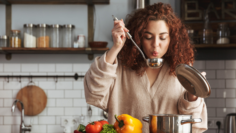 Woman taste-testing soup