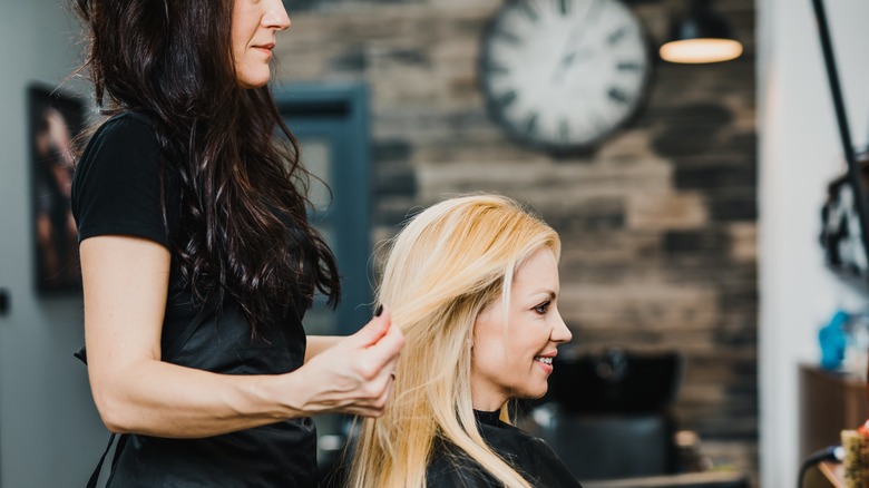 hairstylist holding client's hair