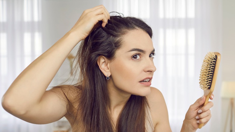 A woman combing her hair with her hands