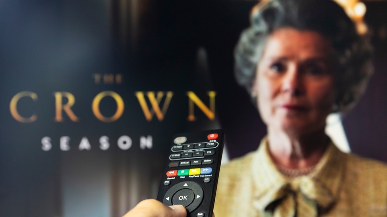 Remote control point at TV with The Crown 