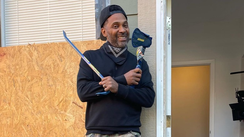 Mike Epps posing with carpentry tools