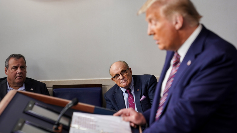 Donald Trump speaks with Chris Christie and Rudy Giuliani watching