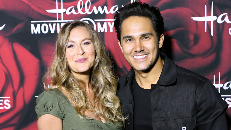 Alexa and Carlos PenaVega smiling at premiere