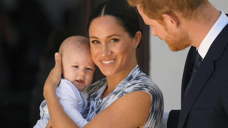 Meghan holding Archie as a baby and smiling