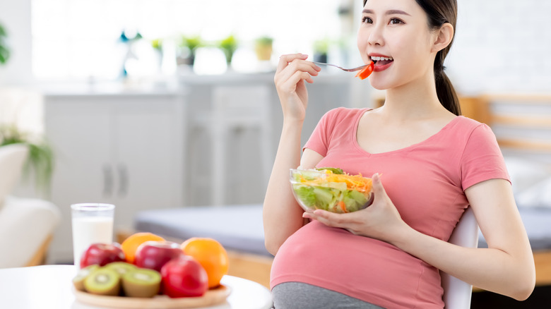 Pregnant woman eating fruit