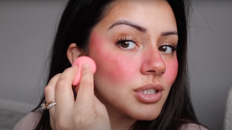 Woman applying blush