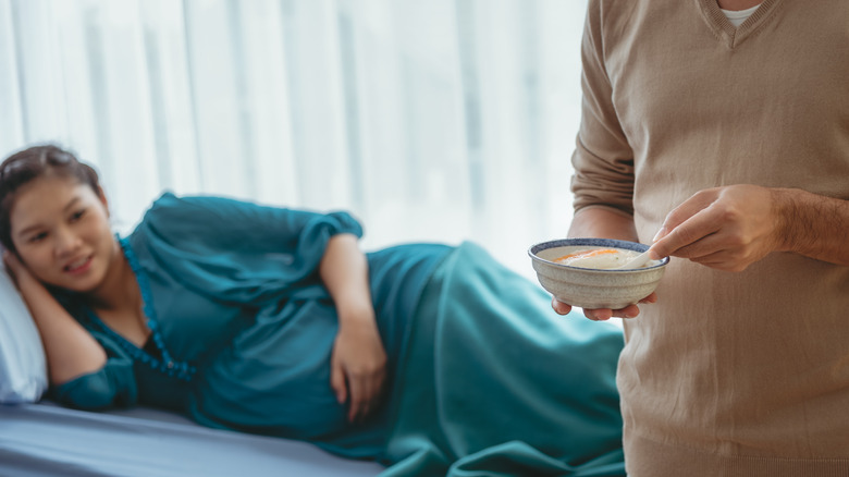 man holding bowl near pregnant woman