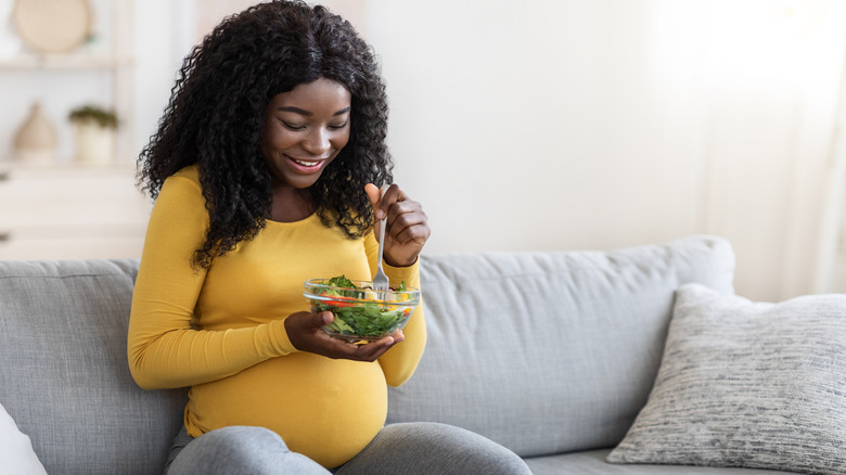 pregnant woman eating a salad