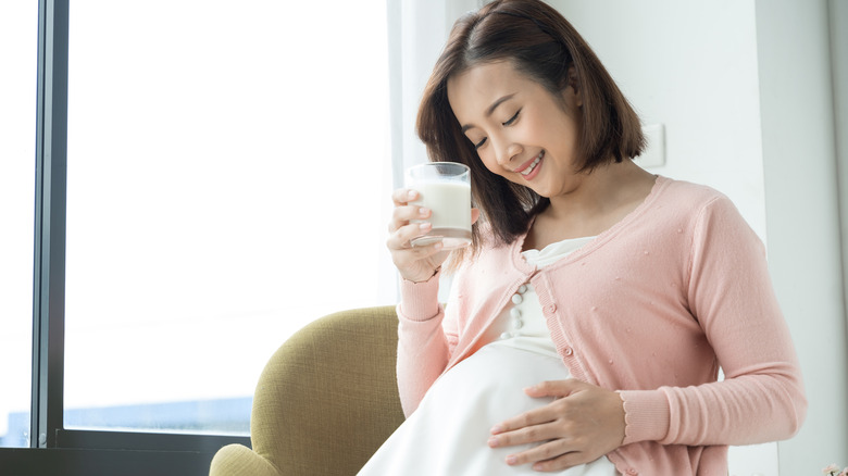 Pregnant woman holding glass of milk