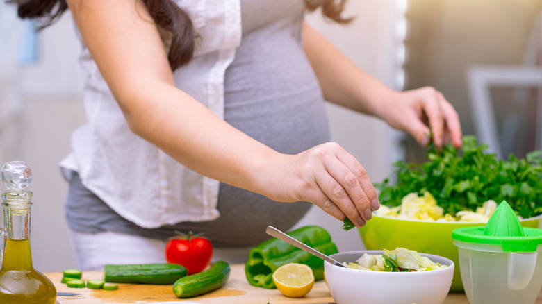 Pregnant woman eating vegetables