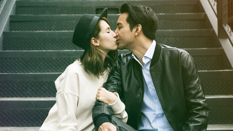 Couple kissing while sitting on steps