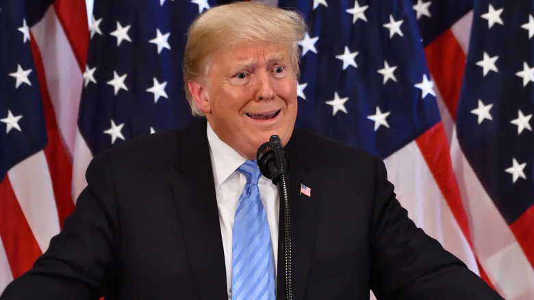 Donald Trump in front of American flags