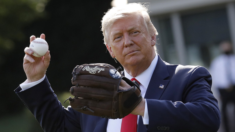 Donald Trump gets ready to throw a baseball