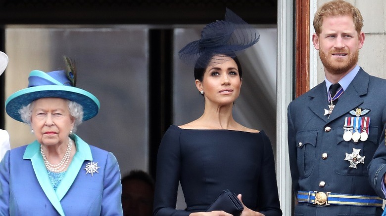 The queen stands away from Meghan Markle and Prince Harry