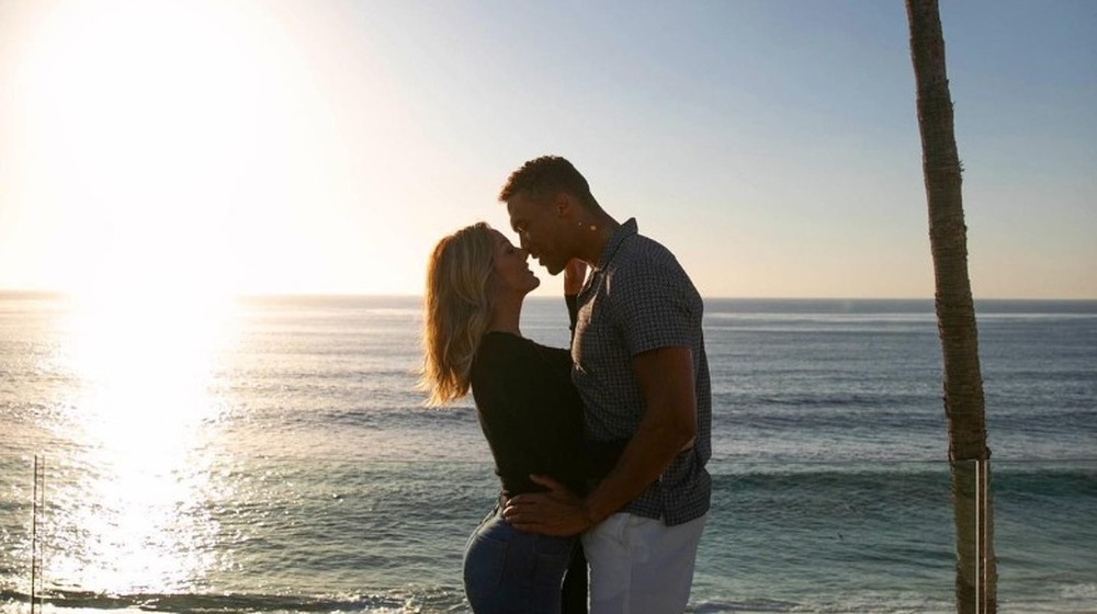 Clare and Dale hug by palm trees