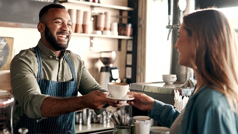 Barista giving customer coffee