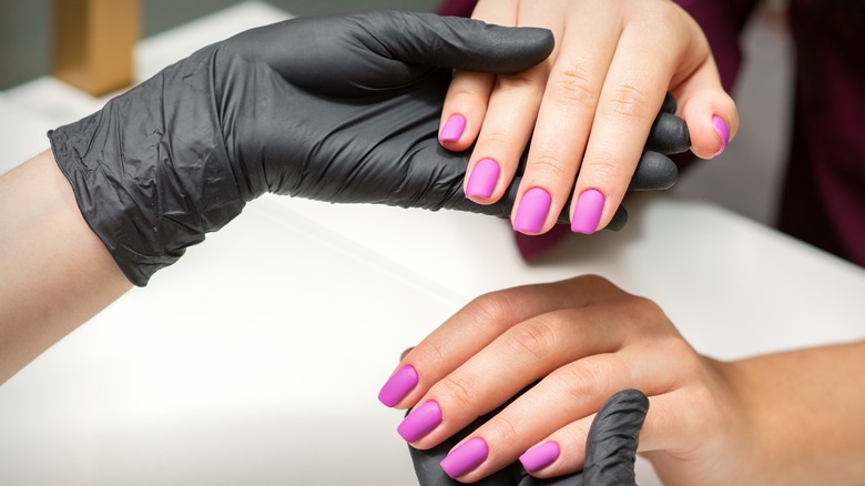 Manicurist showing completed nails