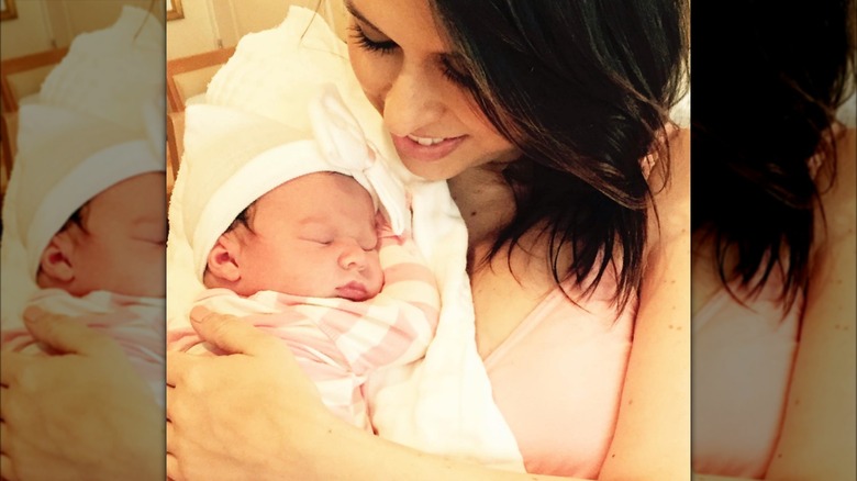 Lacey Chabert holding her newborn daughter