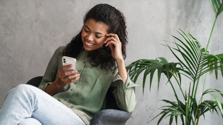 woman smiling near plant