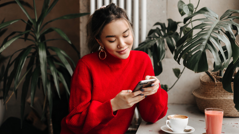 woman texting near plants