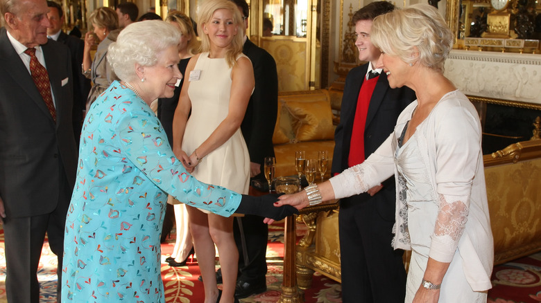 Queen Elizabeth shaking hands with Helen Mirren