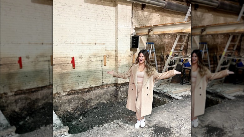 Alison Victoria standing in renovation debris