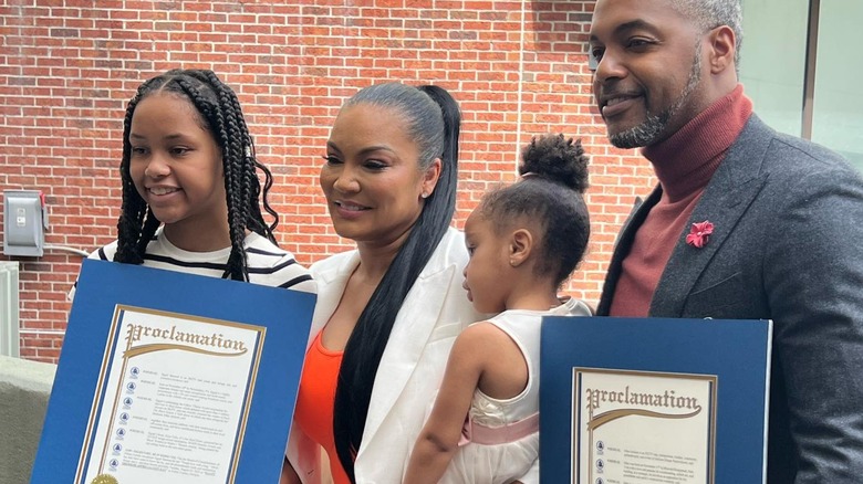 Egypt Sherrod and Mike Jackson pose with children holding certificates