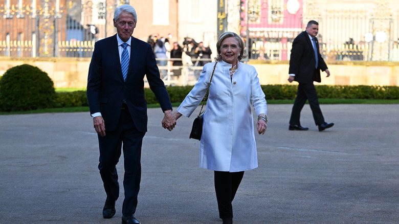 Hillary Clinton holding hands with Bill