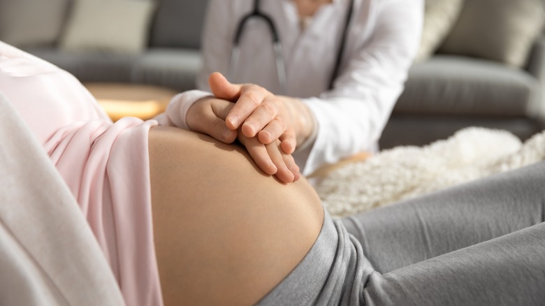 pregnant woman at home with doctor