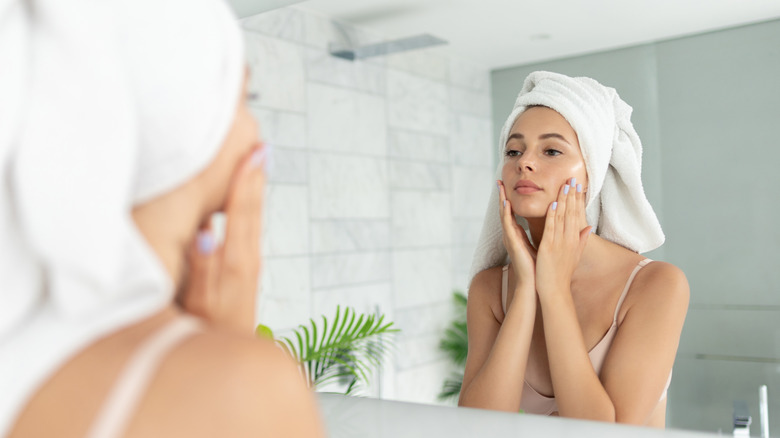 woman doing skincare in mirror