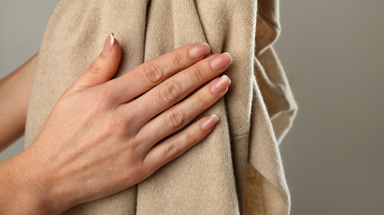 Hand caressing cashmere sweater