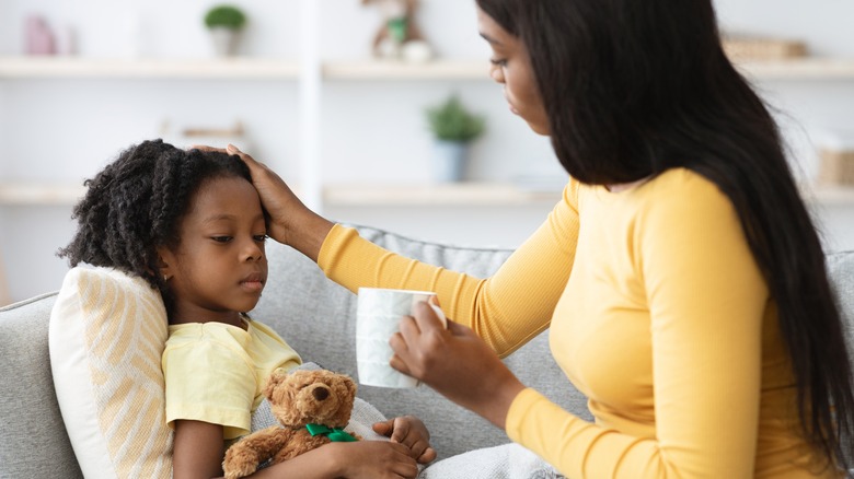 Black mother give sick child tea