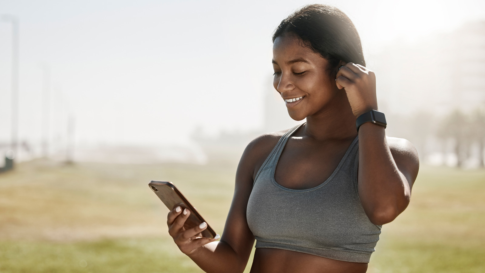 Woman with Headphones and Cell Phone in Sports Bra
