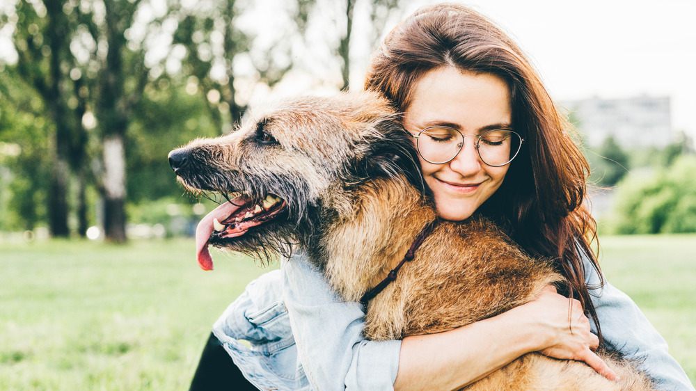 Woman hugging her dog outdoors