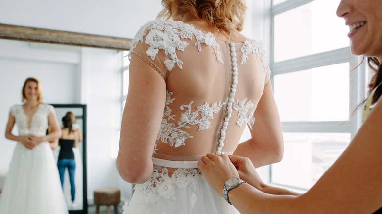 woman adjusting wedding dress back